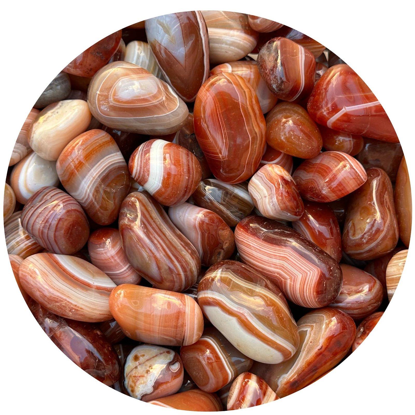 Close-up of a pile of polished, banded agate stones in shades of red